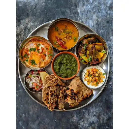 Arhar Dal Tadka, Paneer Butter Masala, Karela Sabzi, Boondi Raita, Chutney, Salad, Paratha.