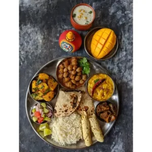 Chana Curry, Dal Fry, Aloo Gutke, Tandoori Paratha, Rice, Salad, Achaar, Masala Chaas, Mango.